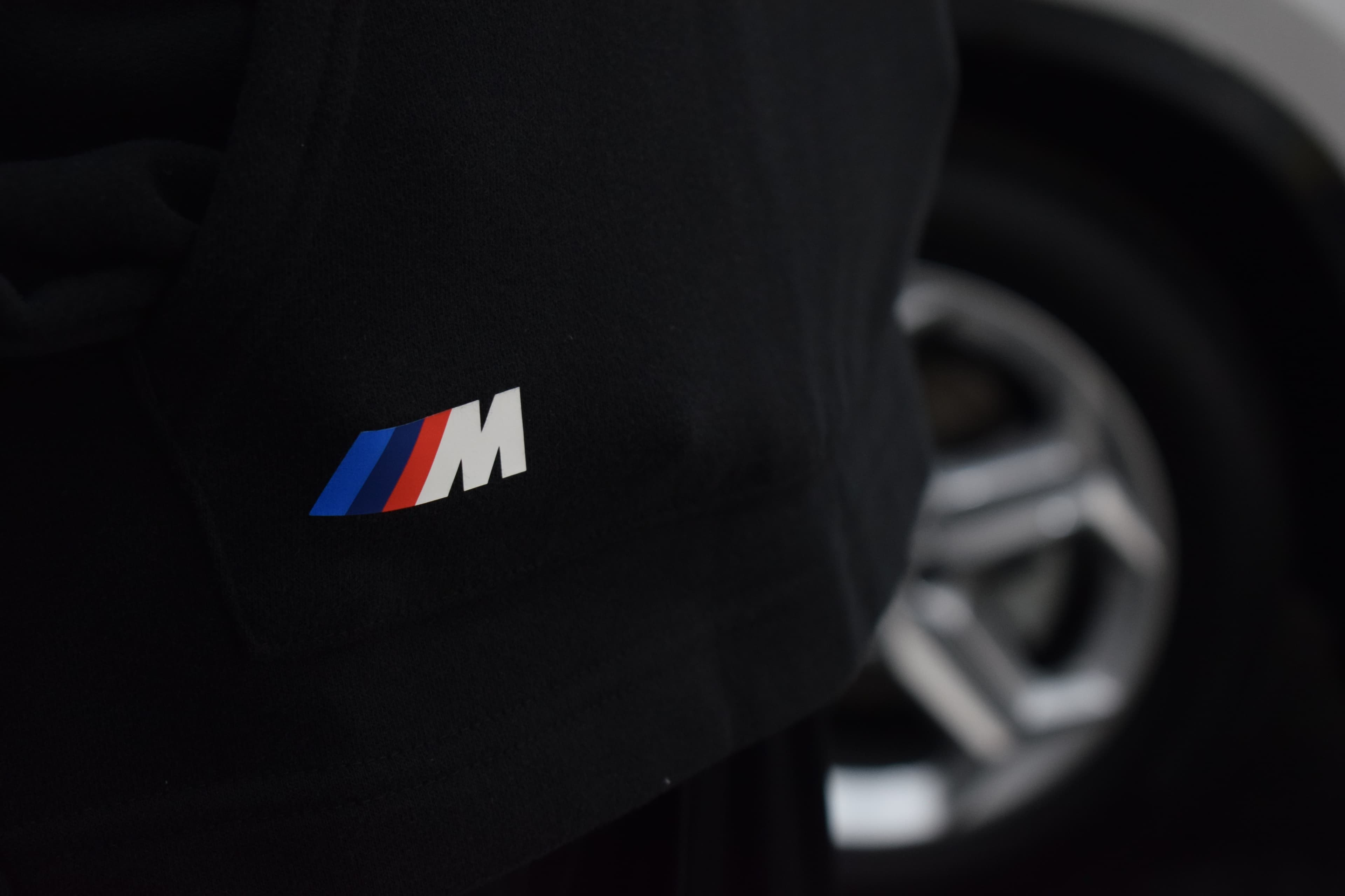 Detalle del logo M bordado en la manga de un buzo negro