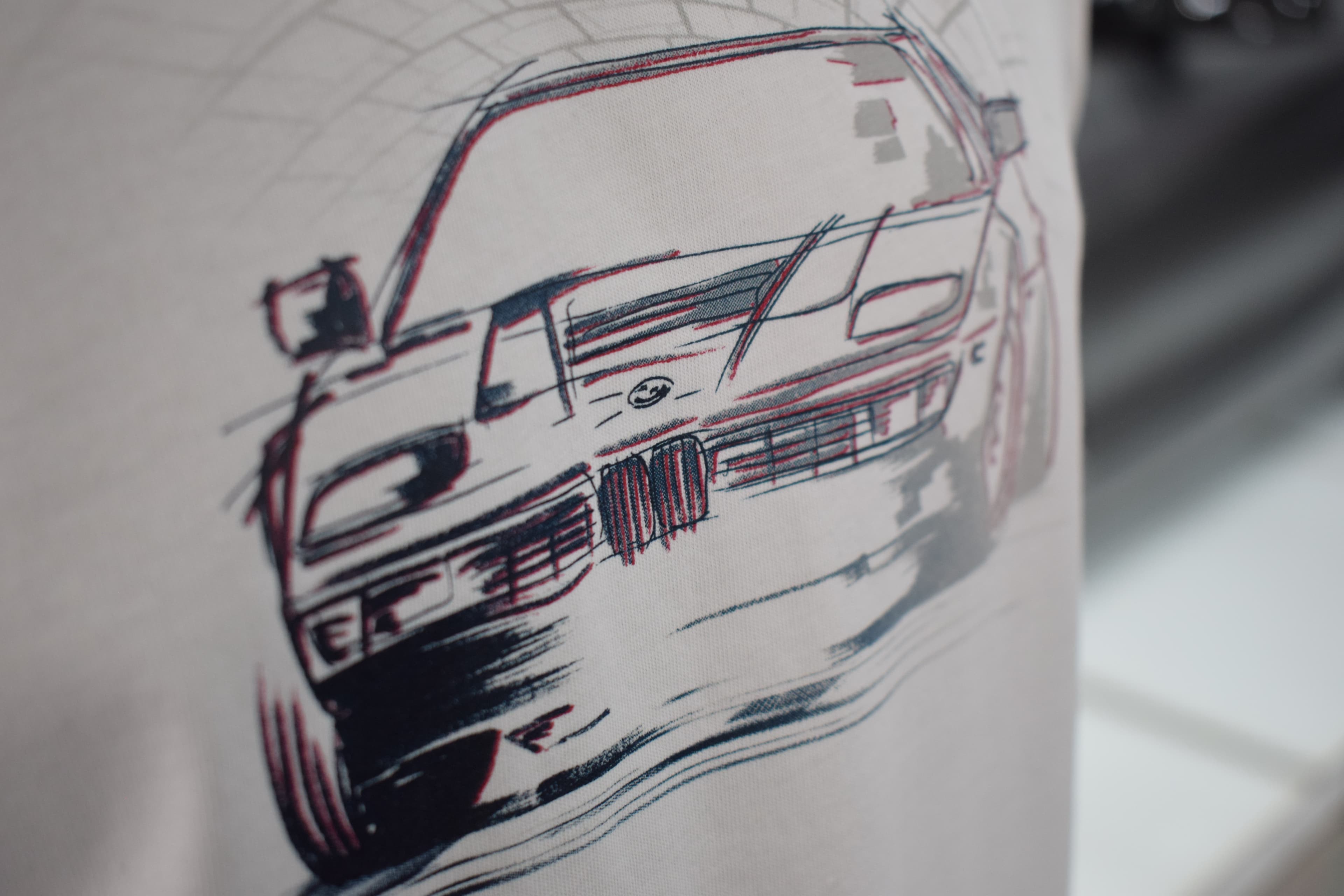 Detalle de la ilustración de un BMW clásico en una remera blanca