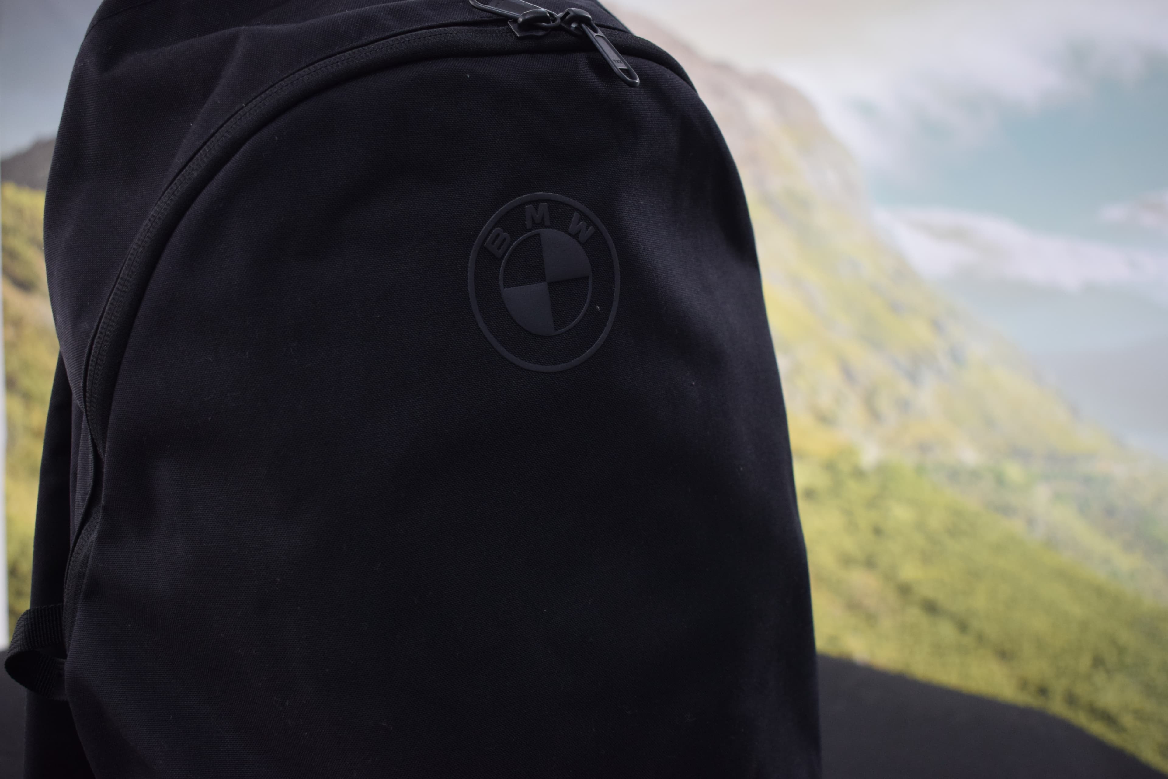 Mochila negra BMW frente a un paisaje de montaña